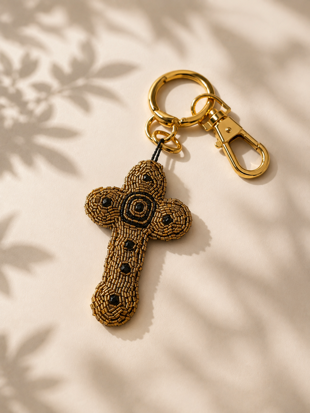 Auralis Charm - beaded gold-bronze cross charm, black center detailing