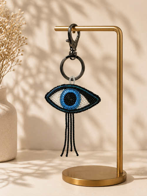 Evil-eye charm hanging from silver-tone clasp