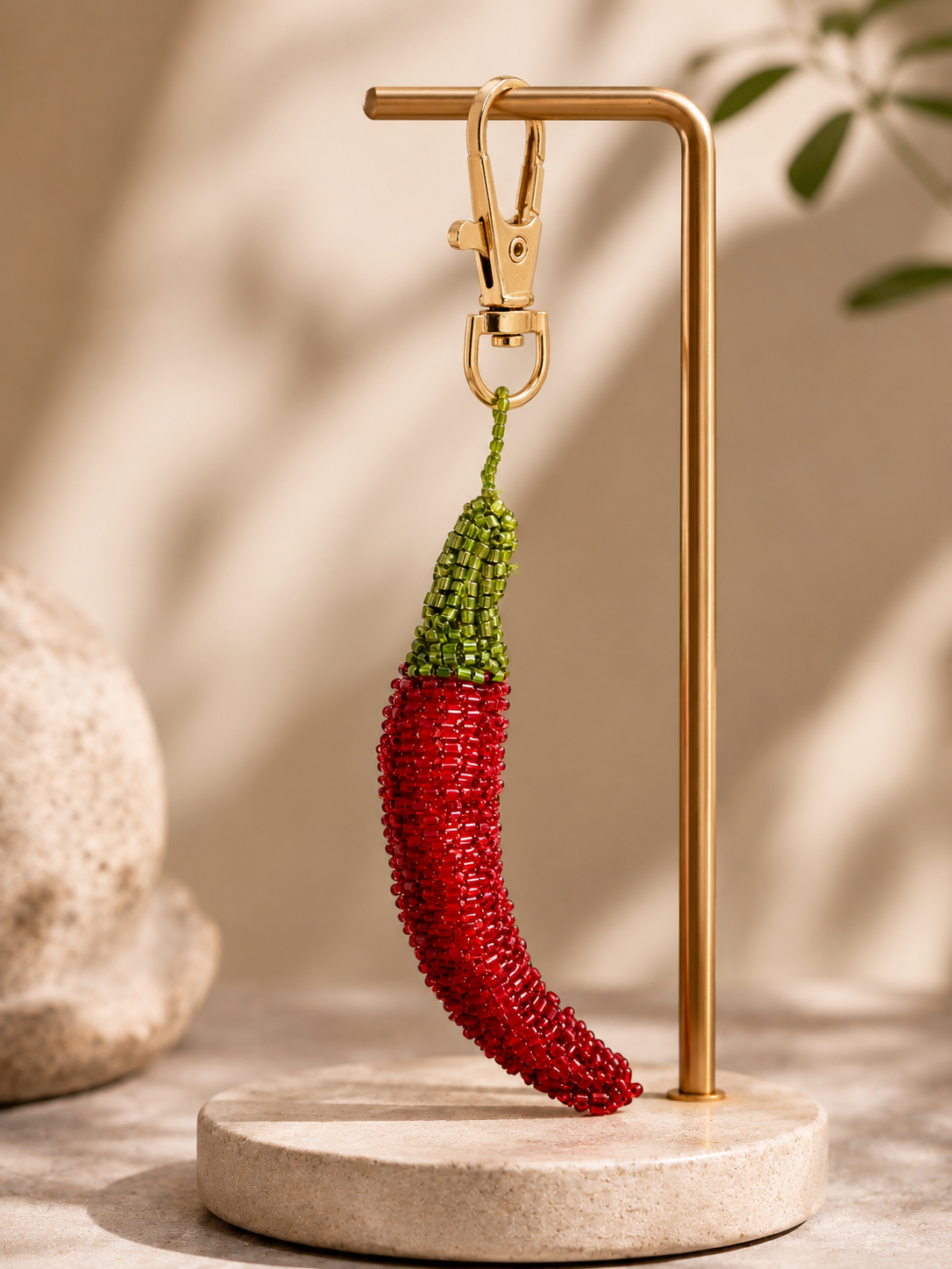 Chili pepper charm hanging from silver-tone clasp