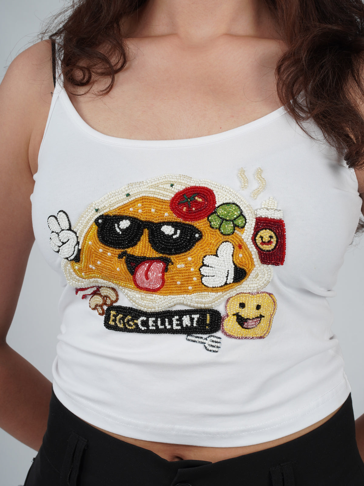 Close-up of hand embroidery on the white EGGZAA Top