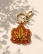 Beaded autumn leaf charm in orange, amber & gold