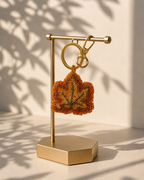 Leaf charm hanging from silver-tone clasp