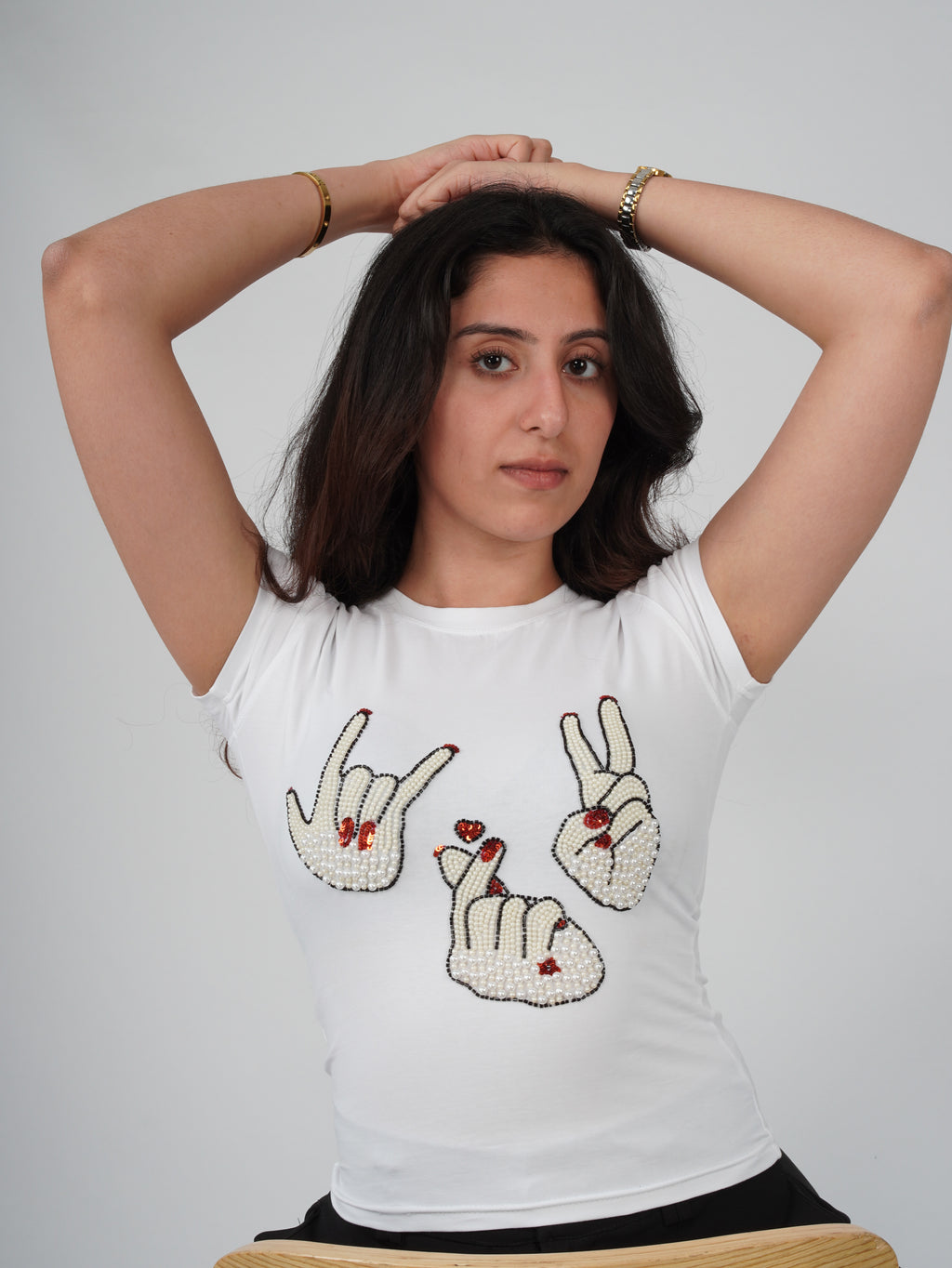 Close-up of hand-embroidered hand-sign artwork on Sarang Sign Top
