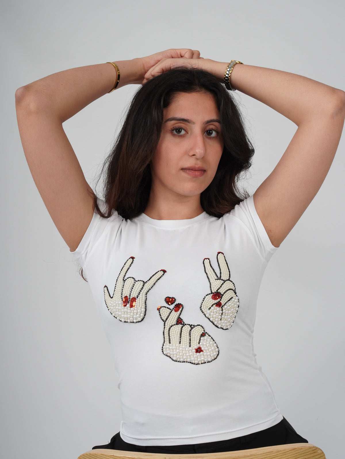 Close-up of hand-embroidered hand-sign artwork on Sarang Sign Top