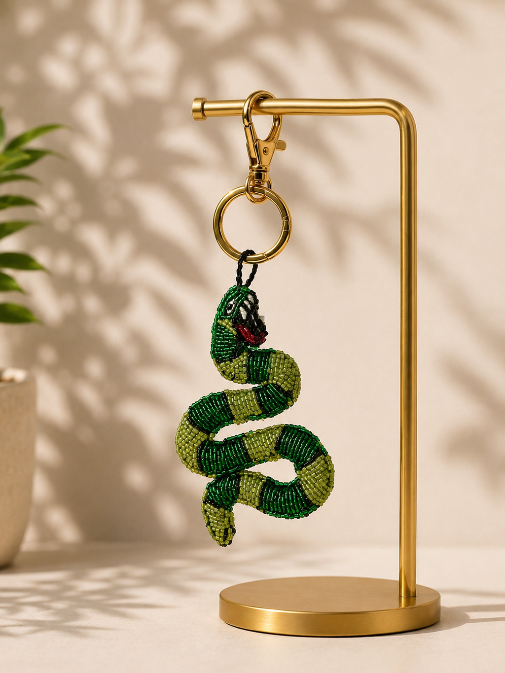 Snake charm hanging from golden-tone clasp