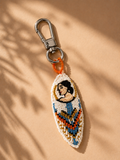 Beaded abstract face charm in white, blue, orange & gold